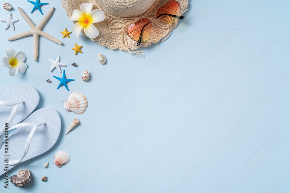 Obraz premium Summer beach background design concept with shells, hat, slipper on blue background.