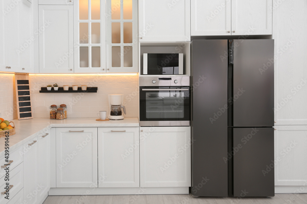 Fototapeta premium Light kitchen interior with stylish furniture and modern equipment