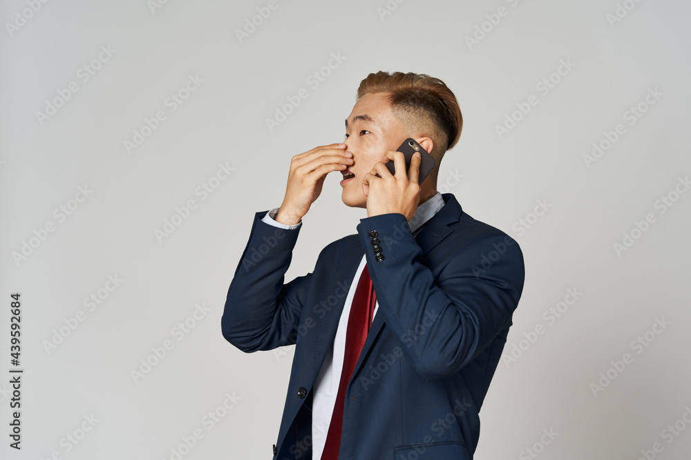 business man in suit of asian appearance talking on the phone official professional business man in suit of asian appearance talking on the phone official professional