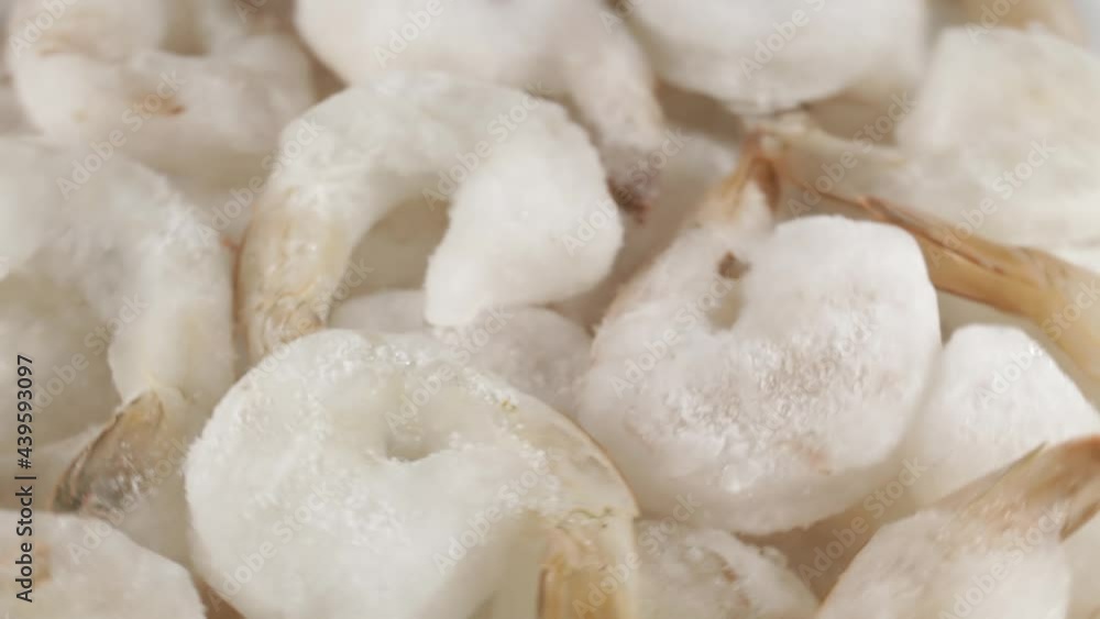 Raw king prawns in glaze rotate around the axis, close-up Raw king prawns in glaze rotate around the axis, close-up