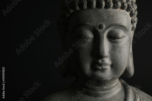 Photography Beautiful stone Buddha sculpture on black background, closeup