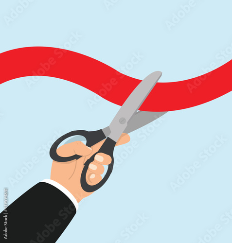 Businessman hand  holding scissors with cutting red ribbon