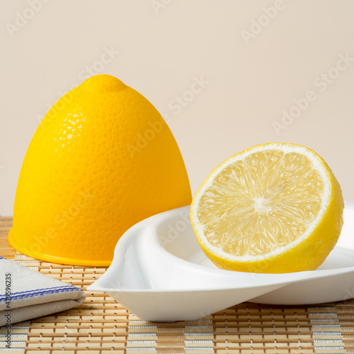 Half a lemon in a lemon plastic bowl on bamboo napkin
