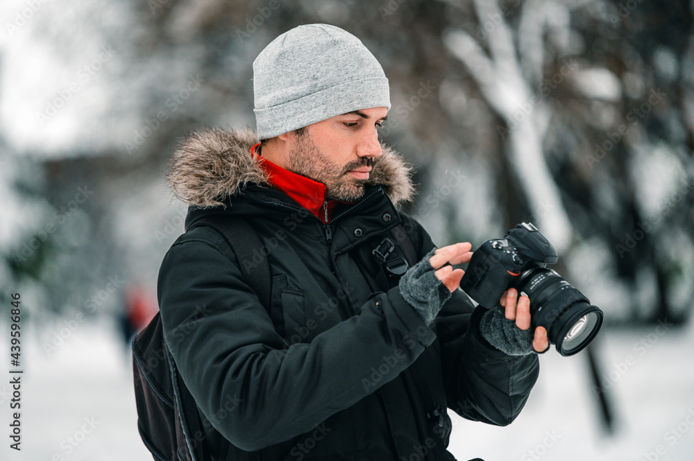 Man using modern photo camera in winter forest Man using modern photo camera in winter forest