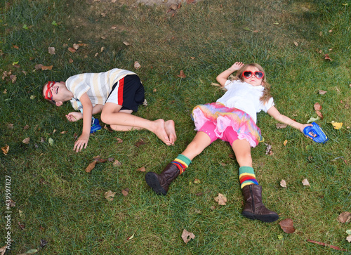 Tired Children Laying on Green Grass Outside
