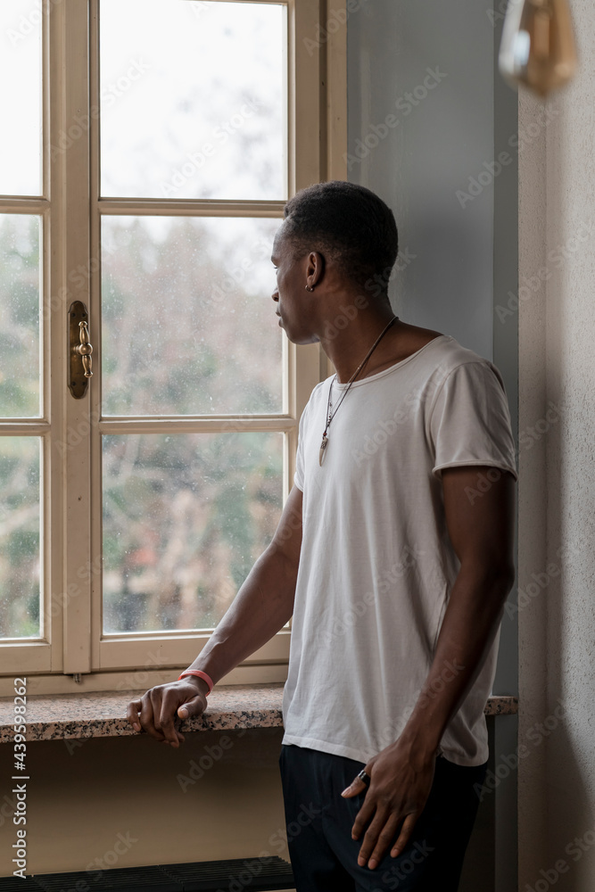 Pensive Black man looking out of the window. Pensive Black man looking out of the window.
