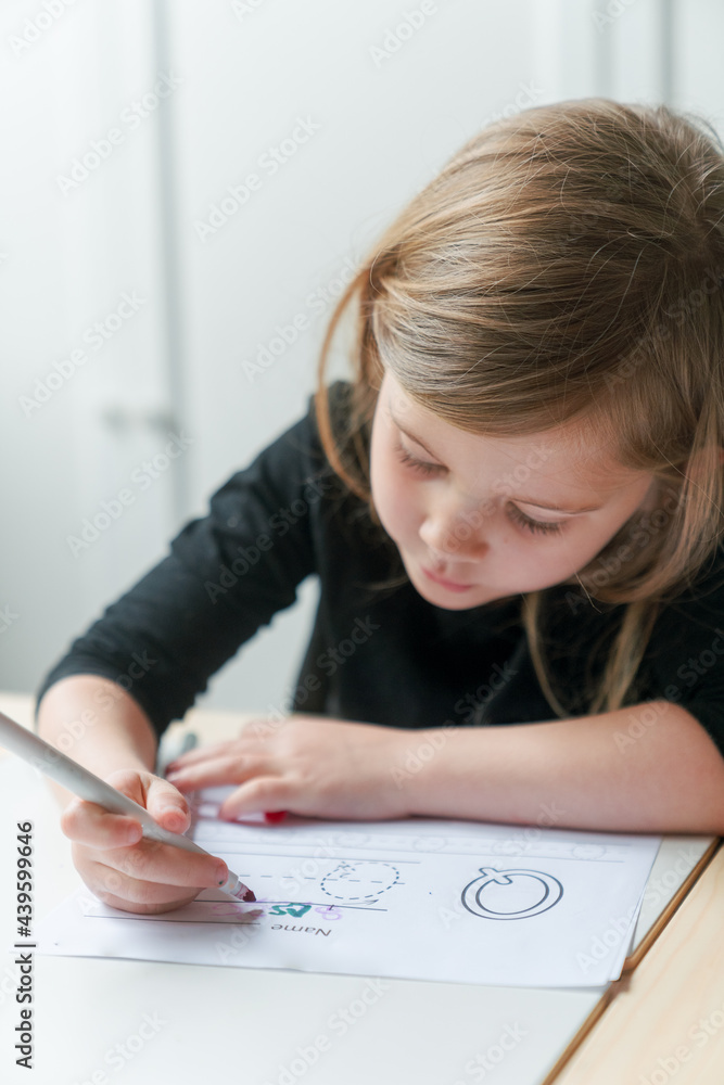 young preschool girl learns writing- leaning forward young preschool girl learns writing- leaning forward
