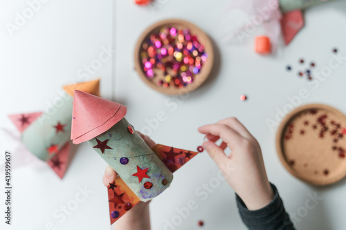 child decorates handmade paper rocket ship  photo