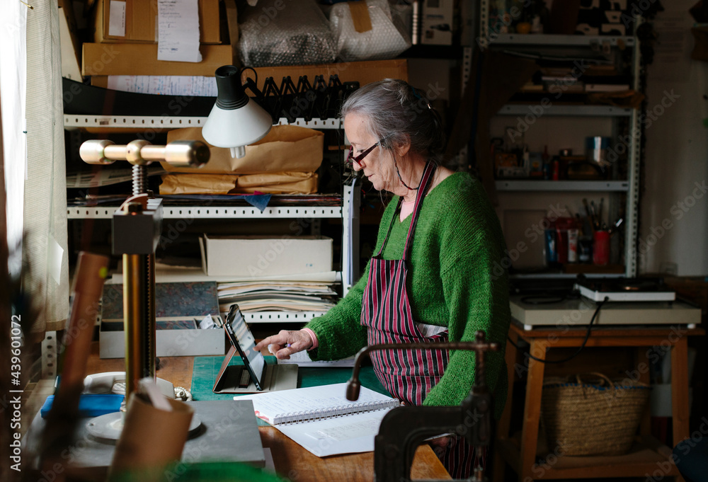 Elderly woman with glasses working in her workshop Elderly woman with glasses working in her workshop