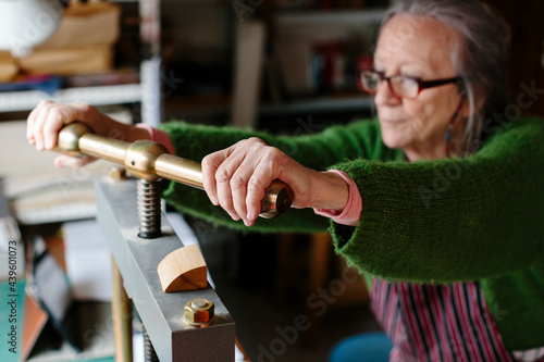 Wallpaper Mural Woman using a paper press in her workshop Torontodigital.ca