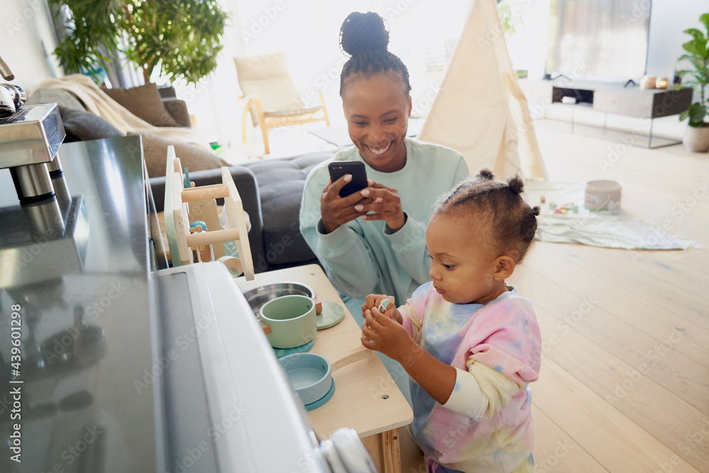 Mother photographs her child playing Mother photographs her child playing