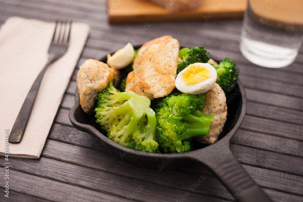chicken breast with broccoli and quail eggs in small cast iron skillet chicken breast with broccoli and quail eggs in small cast iron skillet