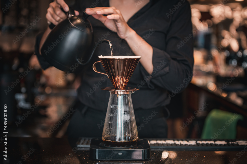 Cafe staff pour hot water into coffee beans to drip coffee for good smell and good quality serve customers ,who order to taste.