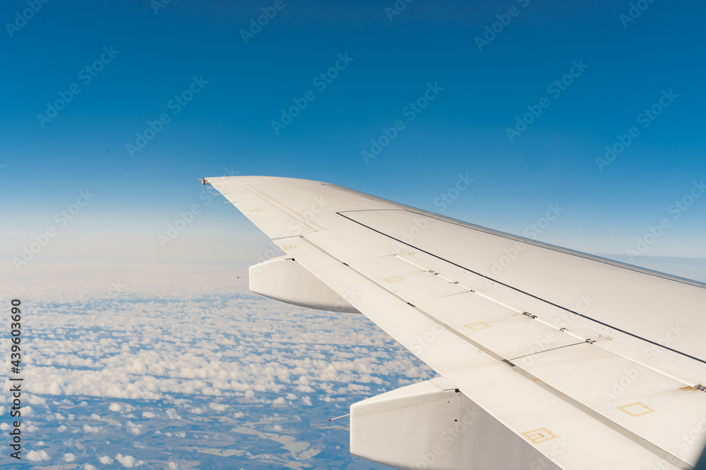 Fototapeta premium Wing of passsanger plane above the land, view from inside