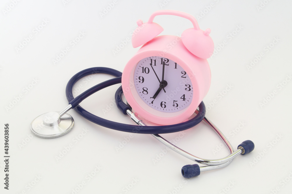 Stethoscope and alarm clock on gray background. Time to check health and medical insurance concept. Stethoscope and alarm clock on gray background. Time to check health and medical insurance concept.