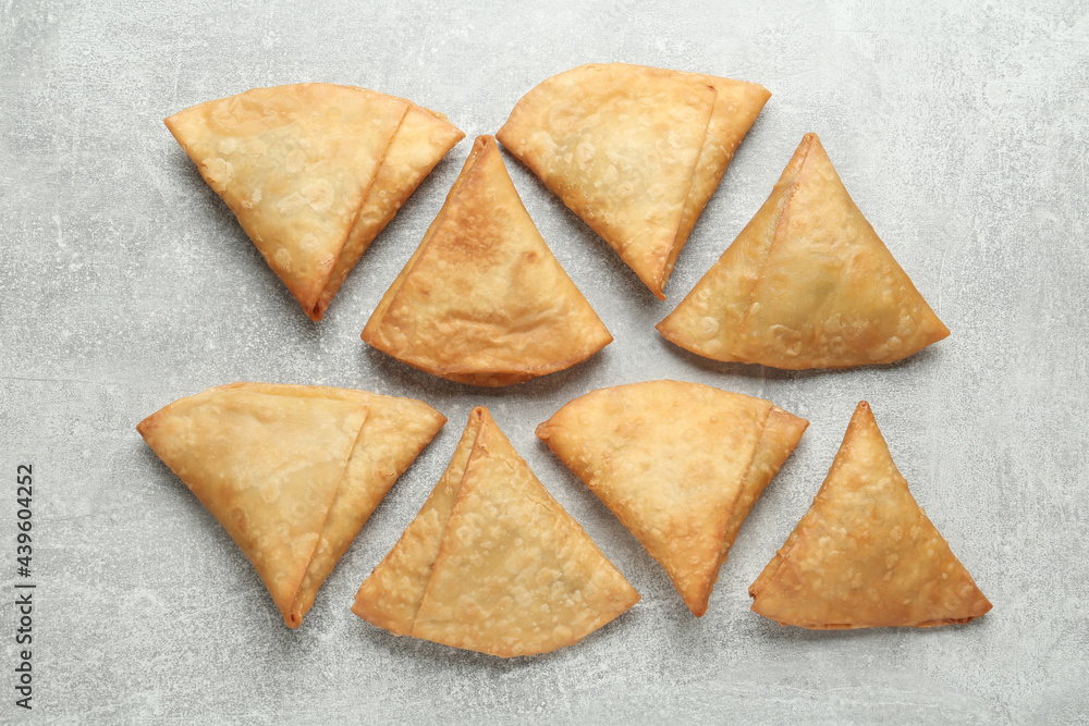 Fresh delicious crispy samosas on grey table, flat lay Fresh delicious crispy samosas on grey table, flat lay