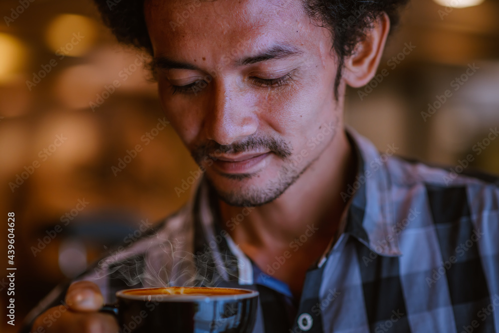 Asian man wear T-shirt drinking and play tablet at cafe shop on relaxing time.