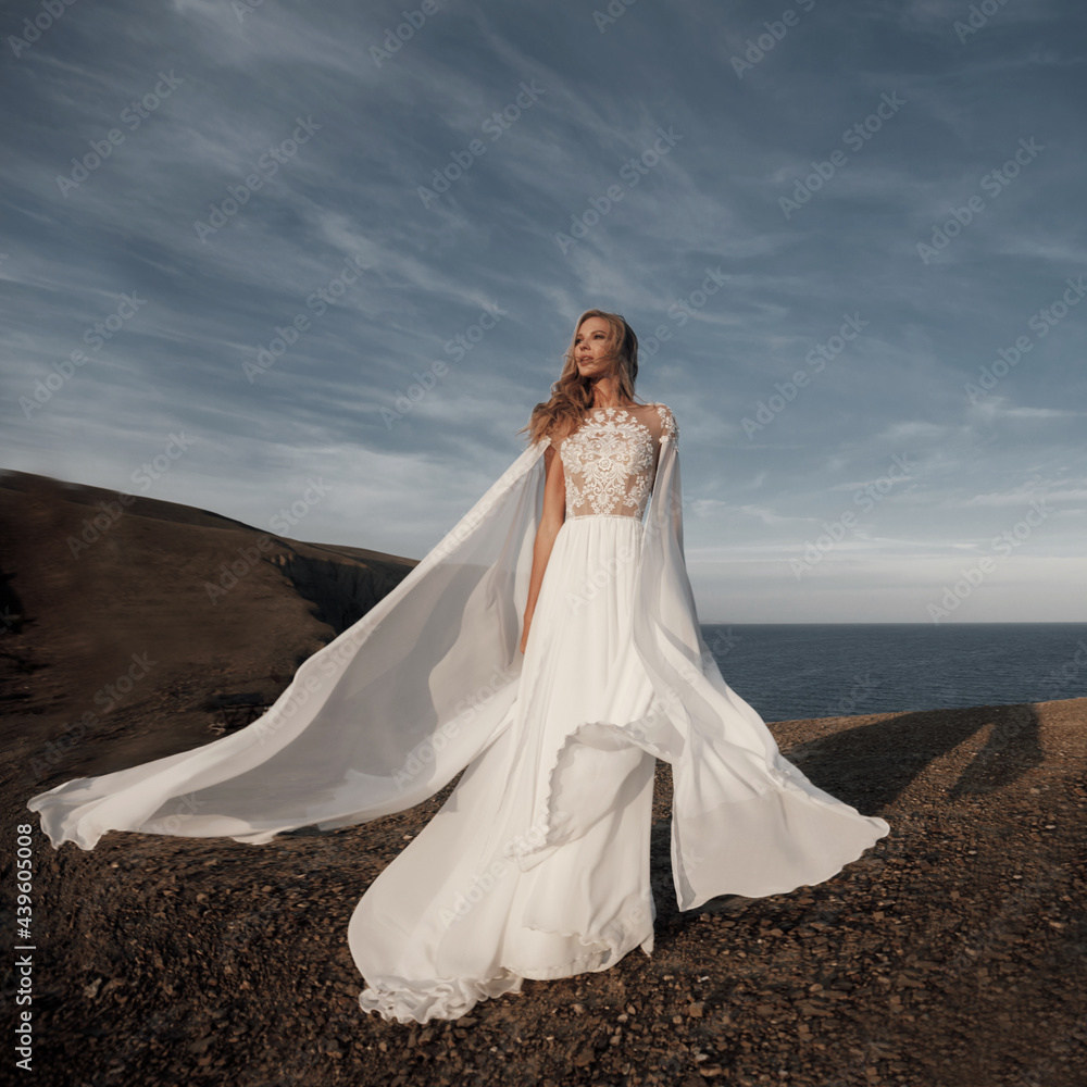 Fashion bride in beautiful wedding dress near the sea