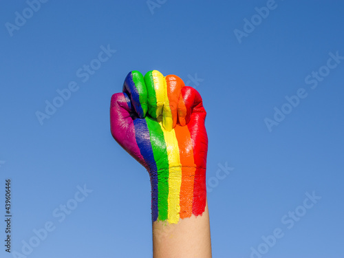 Fototapeta Photo of a raised fist colored with the rainbow color for lgbtq community