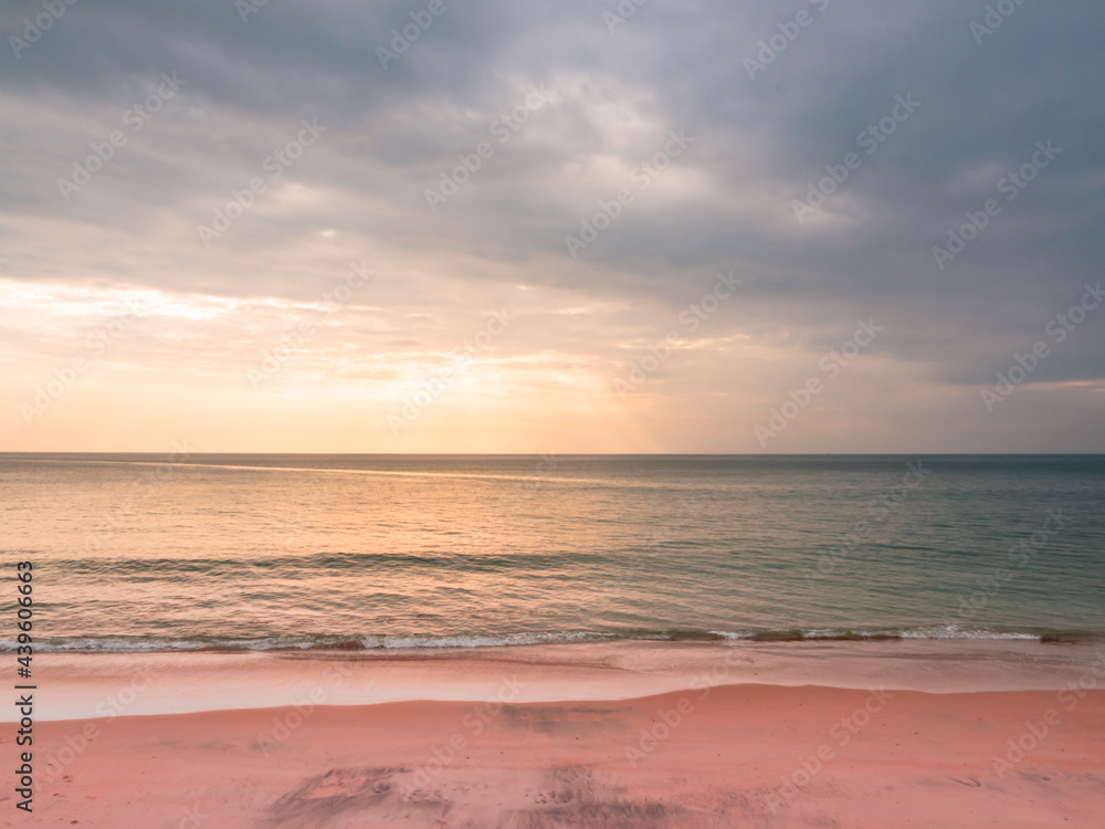 adstract color of pink beach in golden sunset at the beach. dramatic gray cloudy sky above sea water.