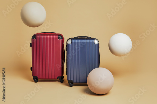 One blue suitcase and one red on a yellow background ready for the summer break