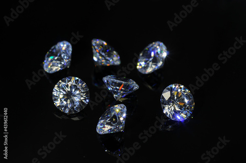Round diamond faceted cubic zirconia set lot, cubic crystalline form of zirconium dioxide (ZrO2) colorless synthesized material. White synthetic gemstones. Diamond imitation. Black isolated background