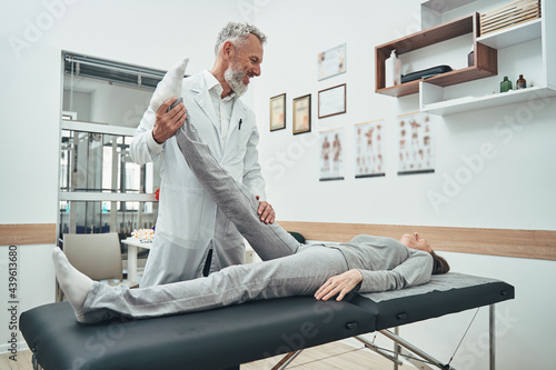 Billede på lærred Experienced physiotherapist diagnosing a lumbar herniated disc