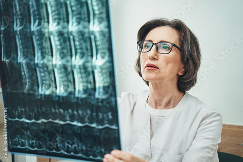 Serious female vertebrologist focused on her work photo