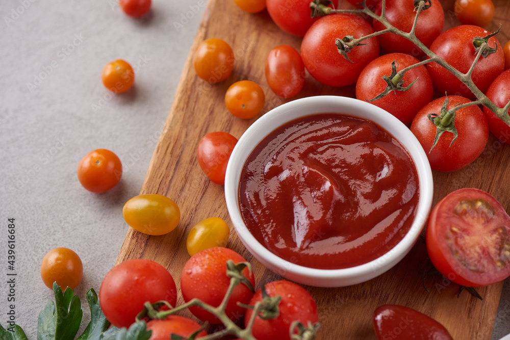 tomato sauce with garlic and vibrant green leaves of the italian parsley plant. tomato ketchup sauce in a bowl with spices, herbs and cherry tomatoes. top view. tomato sauce with garlic and vibrant green leaves of the italian parsley plant. tomato ketchup sauce in a bowl with spices, herbs and cherry tomatoes. top view.
