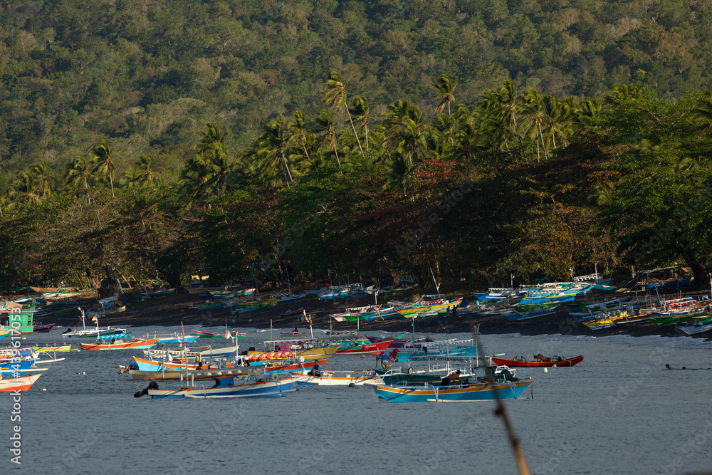 Fototapeta premium Dozens of colorful fishing boats moored near the beach, Tangkoko Nature Park, Sulawesi, Indonesia