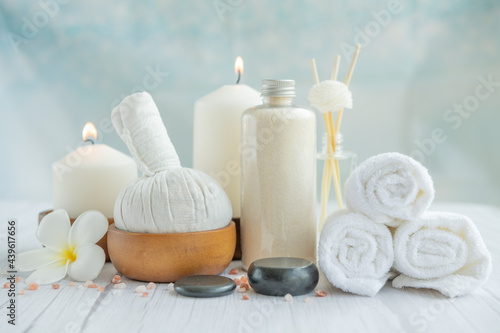 Natural relaxing spa composition on massage table in wellness center with towels, flowers and salt, candle on massage table in spa salon.