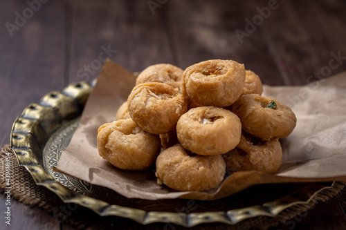 Indian traditional sweet balushahi served on a metal plate on wooden background