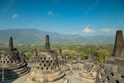 Borobudur Buddhist temple  the largest in the world  with its characteristic bell-shaped stupas  surrounded by mountains Indonesia
