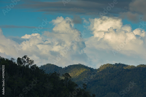 Beautiful clouds over the mountains of Waiego Island, covered by tropical jungle, in the exotic Raja Ampat Islands, Indonesia, Southeast Asia