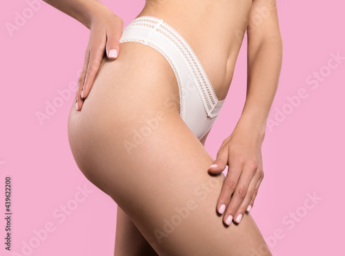 Closeup view of slim woman in underwear on pink background. Cellulite problem concept