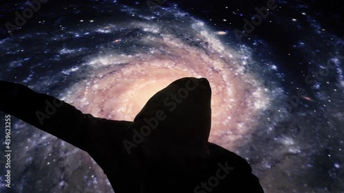 A boxer training (a black silhouette wearing a hoodie and thowing punches), under a surreal background of rotating galaxies.
 photo