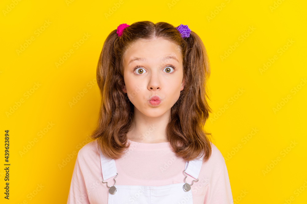 Photo portrait schoolgirl with tails sending air kiss wearing casual clothes isolated bright yellow color background Photo portrait schoolgirl with tails sending air kiss wearing casual clothes isolated bright yellow color background