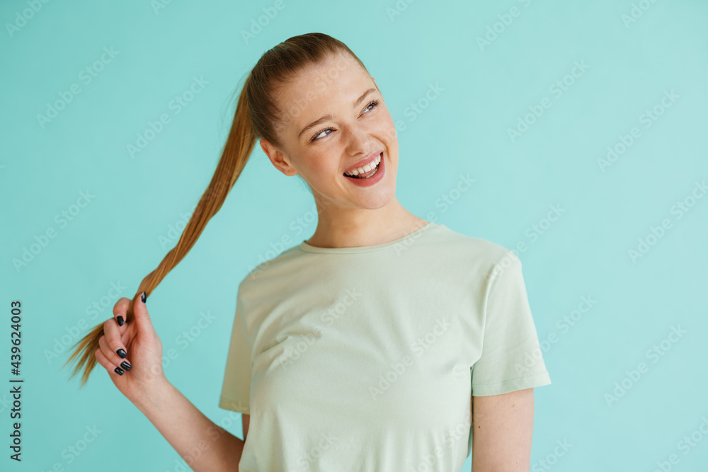 Young blonde white woman smiling while holding her hair Young blonde white woman smiling while holding her hair