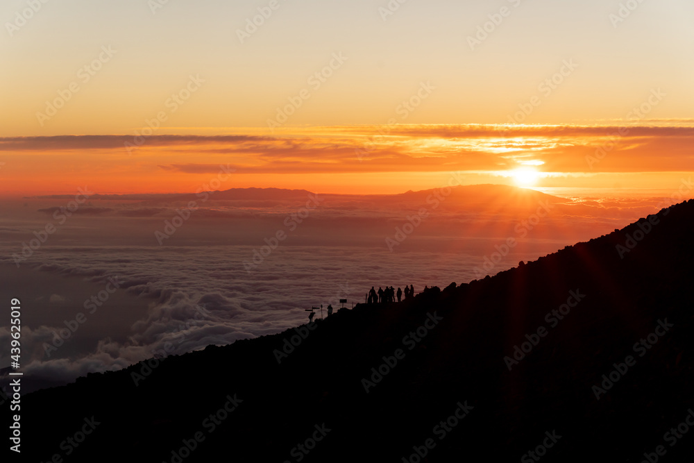 Sunset view from el Teide volcano, Tenerife canary island Spain. Silhouette people. Sun behind clouds	