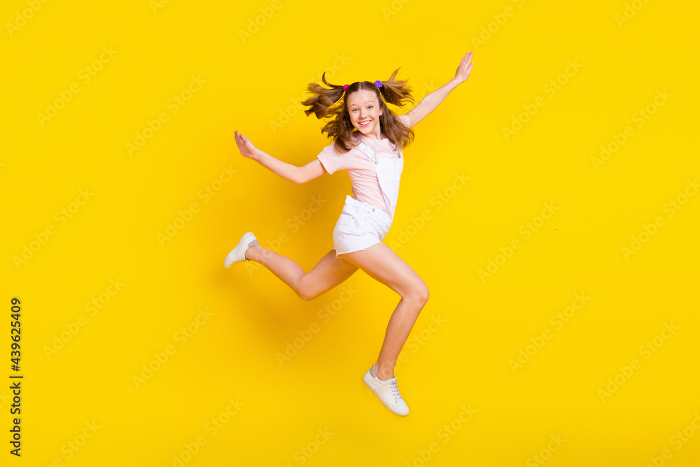 Full length body size view of attractive cheerful girl jumping having fun running isolated over bright yellow color background