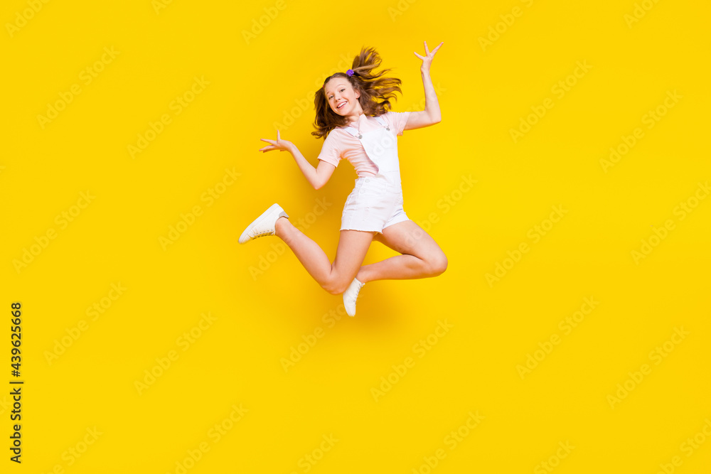 Full length body size view of attractive cheerful girl jumping fooling rest holiday isolated over bright yellow color background Full length body size view of attractive cheerful girl jumping fooling rest holiday isolated over bright yellow color background