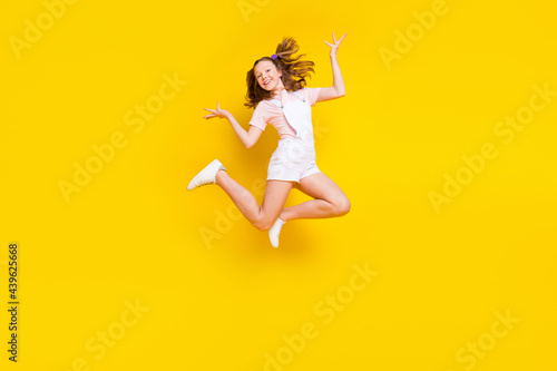 Full length body size view of attractive cheerful girl jumping fooling rest holiday isolated over bright yellow color background