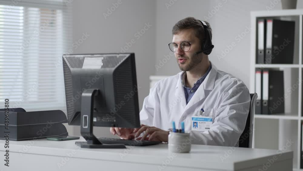 male doctor or nurse with headset and computer working at hospital. Close up of medical operator with headphone consulting patients. Medical man operator working in a medicine call centre male doctor or nurse with headset and computer working at hospital. Close up of medical operator with headphone consulting patients. Medical man operator working in a medicine call centre