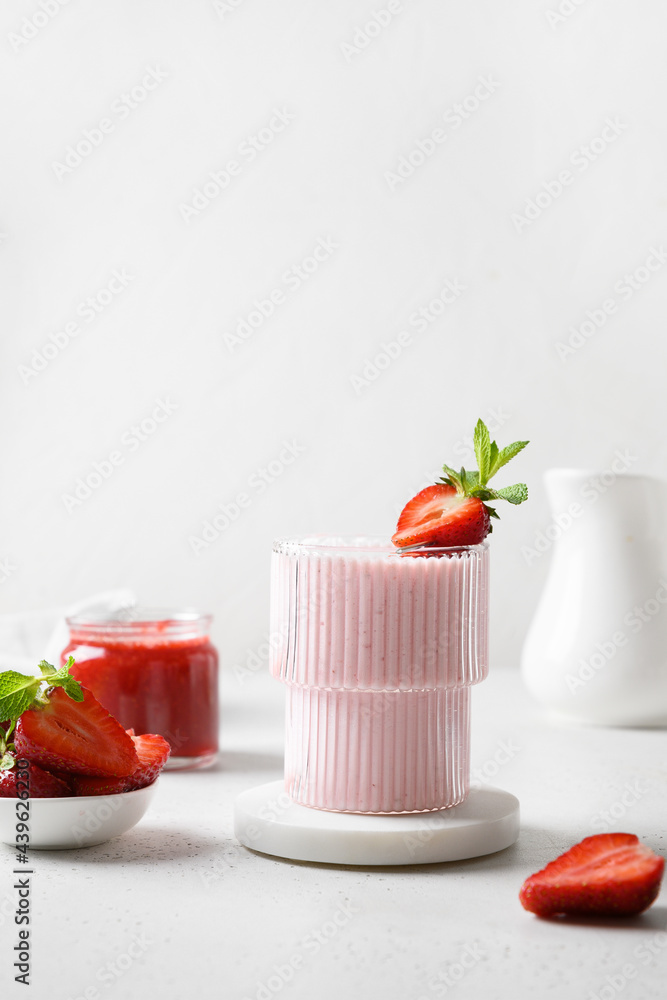 Strawberry lassi, smoothie or milkshake on a white background. Vertical format. Healthy dairy Indian beverge. Strawberry lassi, smoothie or milkshake on a white background. Vertical format. Healthy dairy Indian beverge.