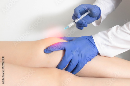 The doctor injects an ozone-oxygen mixture into the patient's knee joint to relieve muscle spasm and inflammation. Ozone therapy, copy space for text