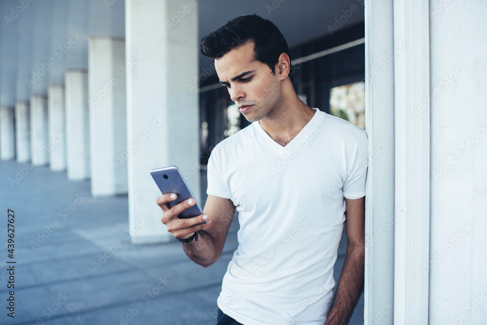 Young hipster guy in casual clothes connecting to wireless for chatting and messaging in social media networks, millennial man checking mobile sms writing text for sending via smartphone application Young hipster guy in casual clothes connecting to wireless for chatting and messaging in social media networks, millennial man checking mobile sms writing text for sending via smartphone application