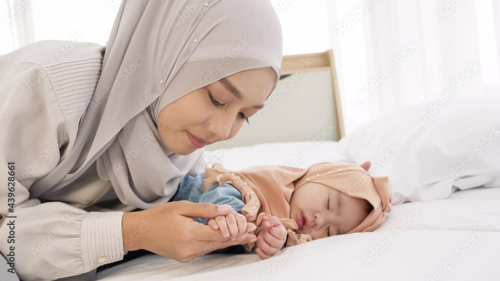 Mother holding baby girl hand and kiss while sleeping. Mother and baby bonding, Protection, Health care, love Mother holding baby girl hand and kiss while sleeping. Mother and baby bonding, Protection, Health care, love