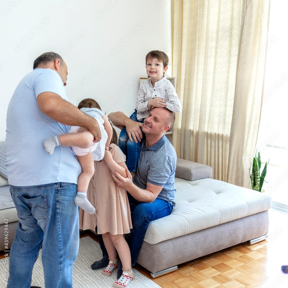 Cropped shot of an affectionate family of five on the sofa at home during the day. Family having fun together at home. Happy couple playing, having fun, hugging with their kids at home. Copy space. Cropped shot of an affectionate family of five on the sofa at home during the day. Family having fun together at home. Happy couple playing, having fun, hugging with their kids at home. Copy space.