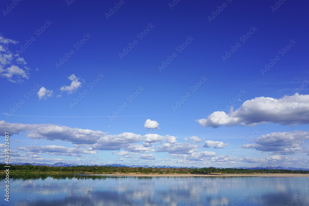 Blue sky with clouds and a beautiful river and forest