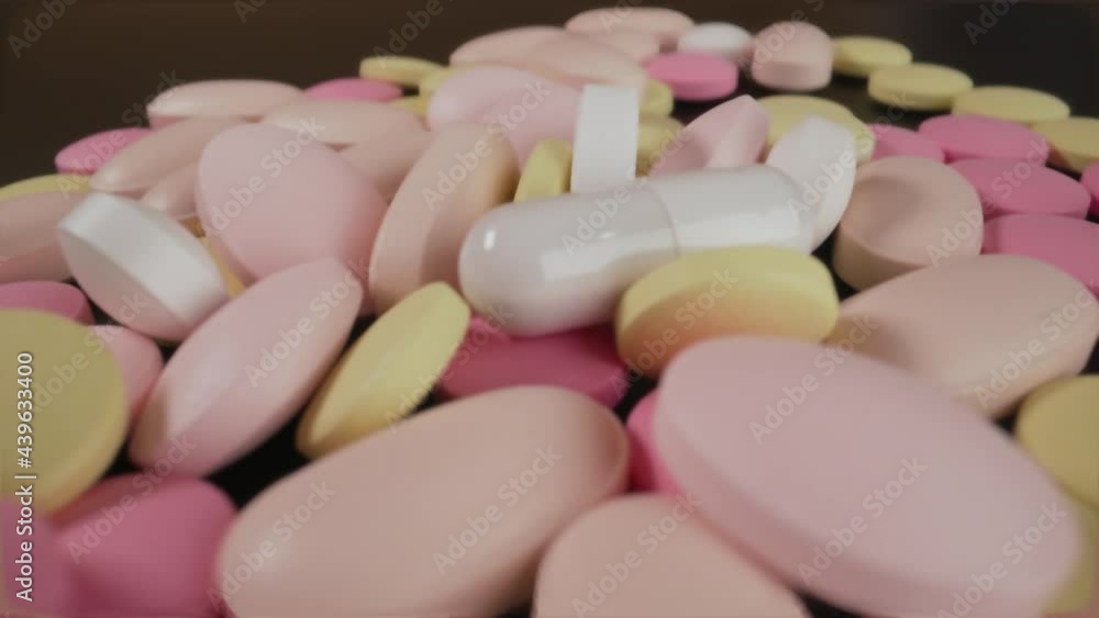 Multi-colored pills lie on the table. The tablets are scattered onto the rotating medical table. Analysis laboratory. The invention of pills for coronavirus. Tablets on a turntable. Multi-colored pills lie on the table. The tablets are scattered onto the rotating medical table. Analysis laboratory. The invention of pills for coronavirus. Tablets on a turntable.